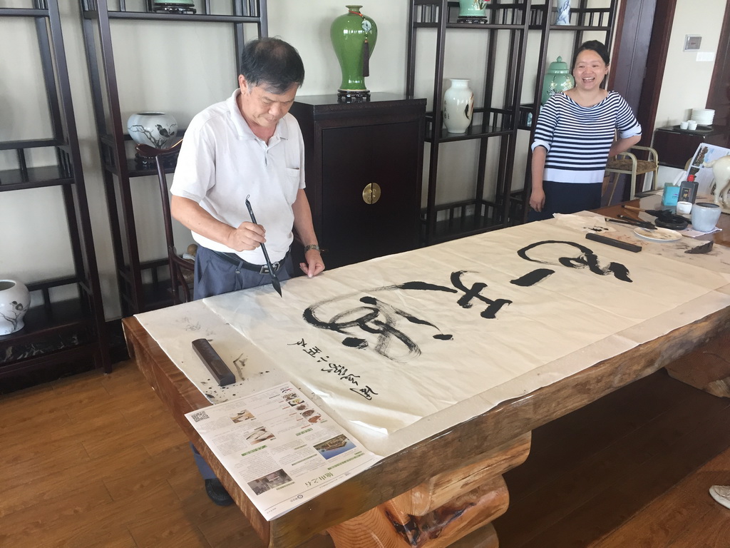 Miaomiao and Miaomiao`s father doing calligraphy at our lunch restaurant at the crossing of Binhai Avenue and Changtong Road