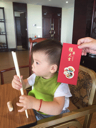 Max with a red envelope at our lunch restaurant at the crossing of Binhai Avenue and Changtong Road