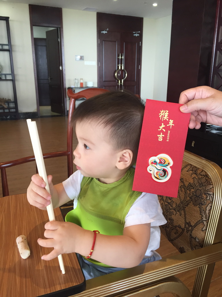 Max with a red envelope at our lunch restaurant at the crossing of Binhai Avenue and Changtong Road