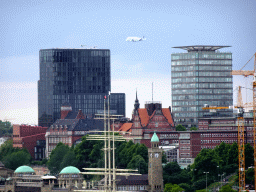 Airplane flying above the northwest side of the city with the St. Pauli Piers, viewed from the viewing point of the Elbphilharmonie concert hall