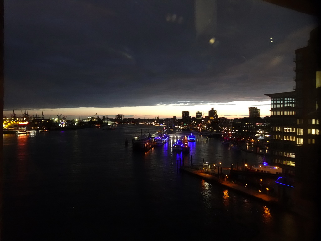 Boats in the Elbe river, the Niederhafen harbour and the St. Pauli Piers, viewed from the viewing window of the Elbphilharmonie concert hall, by night