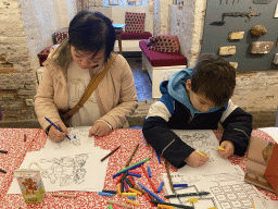 Miaomiao and Max with a colouring page at the museum room at the basement of the main building of the Heeswijk Castle, during the `Sint op het Kasteel 2022` event
