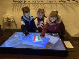 Max and his cousins with a screen at the history room at the basement of the main building of the Heeswijk Castle, during the `Sint op het Kasteel 2022` event