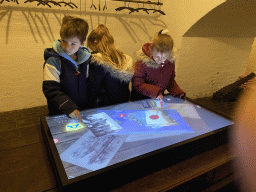 Max and his cousins with a screen at the history room at the basement of the main building of the Heeswijk Castle, during the `Sint op het Kasteel 2022` event