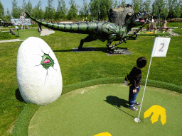 Max with dinosaur, snake and egg statues at the miniature golf course at the HistoryLand museum