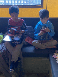 Max and his friend playing with Pokémon cards on the sofa in the living room of our safari tent at the Safari Resort at the Safaripark Beekse Bergen