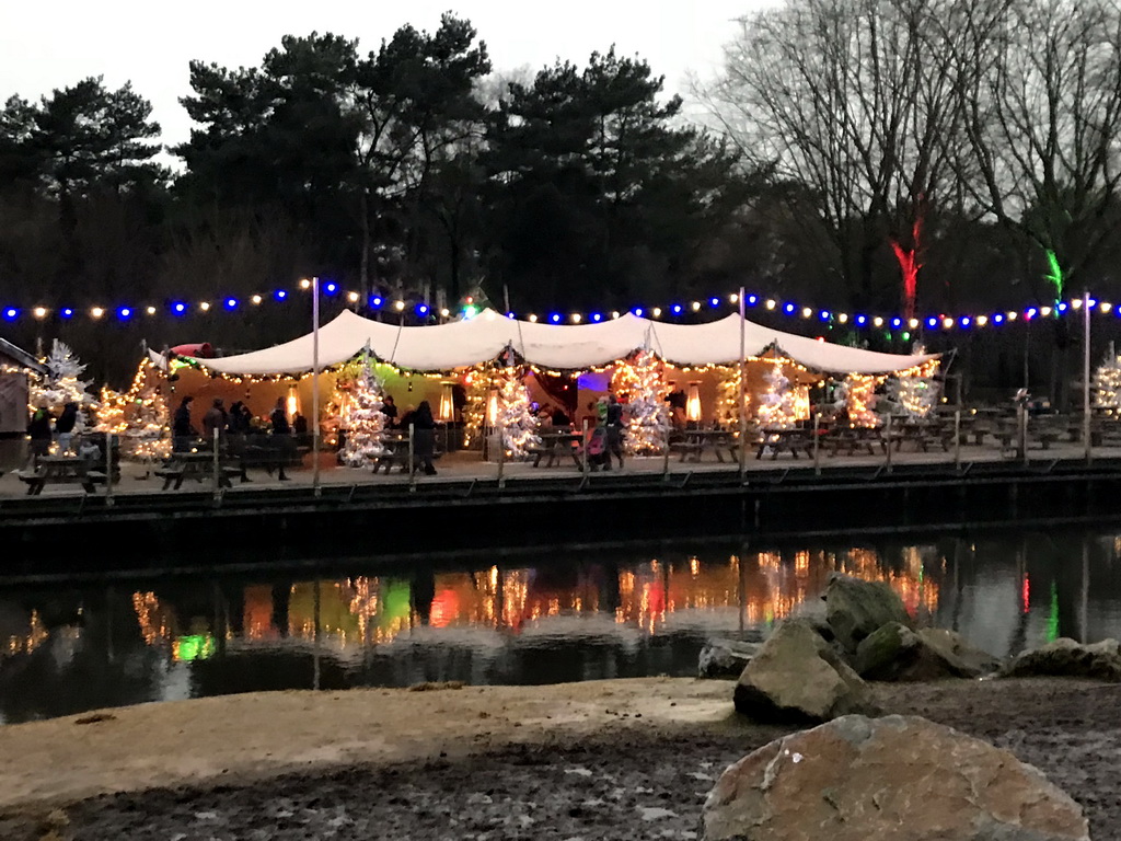 Tents with lights and decorations at the Kongoplein square at the Safaripark Beekse Bergen, during the Winterdroom period, at sunset