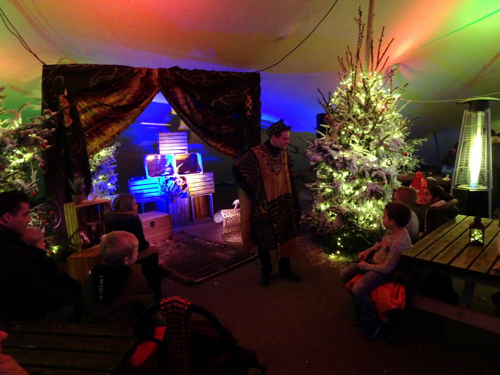 Story teller at the Verhalenverteller attraction at the Kongoplein square at the Safaripark Beekse Bergen, during the Winterdroom period, at sunset