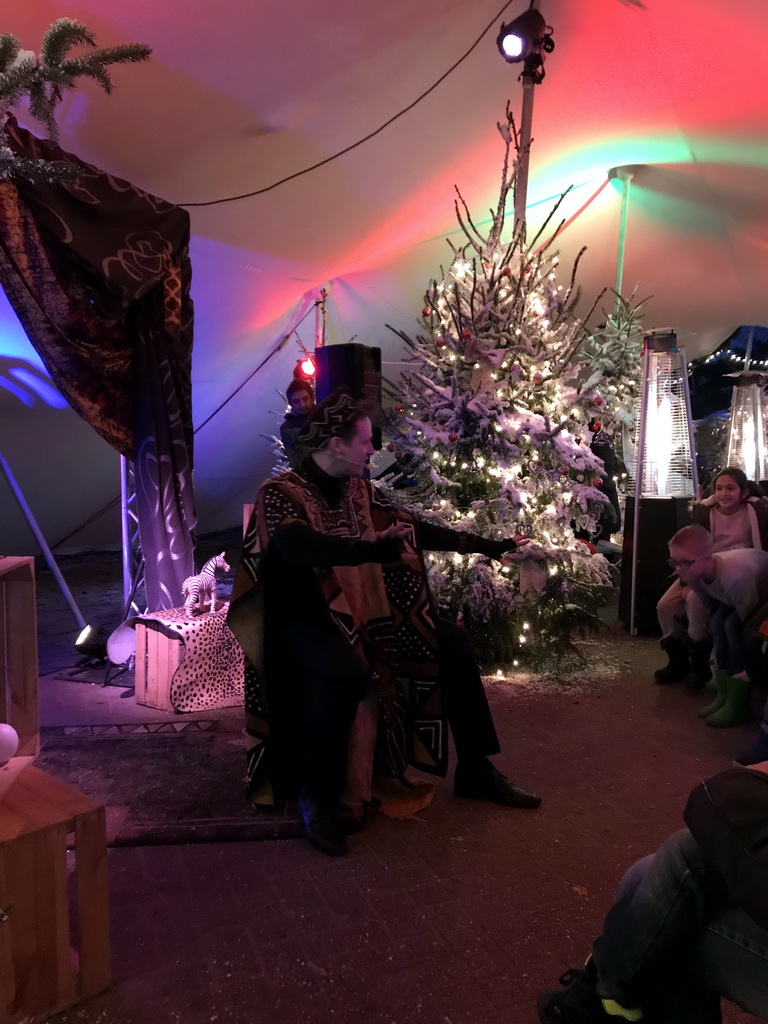 Story teller at the Verhalenverteller attraction at the Kongoplein square at the Safaripark Beekse Bergen, during the Winterdroom period, at sunset