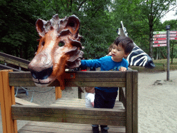 Max with lion and zebra masks at the playground near the Elephant enclosure at the Safaripark Beekse Bergen