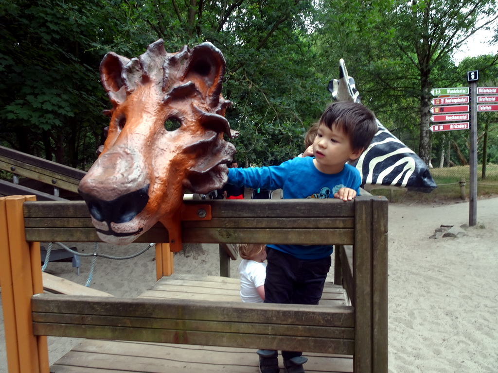 Max with lion and zebra masks at the playground near the Elephant enclosure at the Safaripark Beekse Bergen