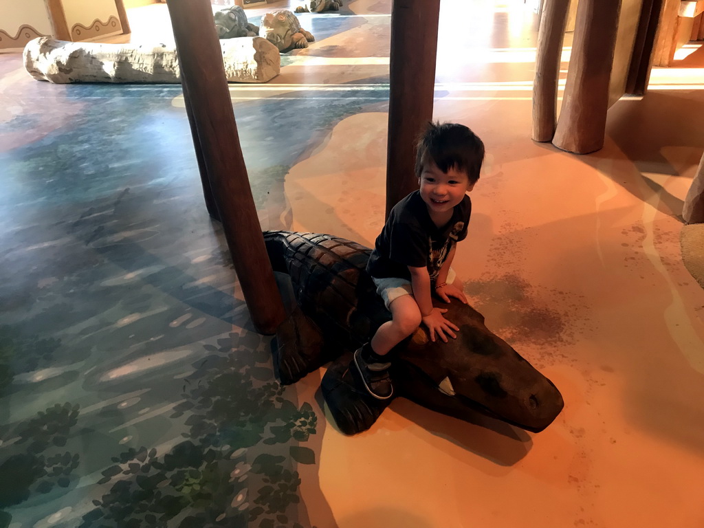 Max on a crocodile statue at the Ranger Basecamp at the Safari Resort at the Safaripark Beekse Bergen