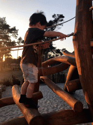 Max at the playground at Karibu Town at the Safari Resort at the Safaripark Beekse Bergen, at sunset