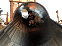 Max on the slide at the playground at Karibu Town at the Safari Resort at the Safaripark Beekse Bergen, at sunset