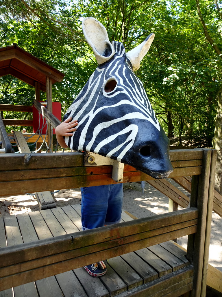 Max with a Zebra mask at the playground near the Ranger Camp at the Safaripark Beekse Bergen
