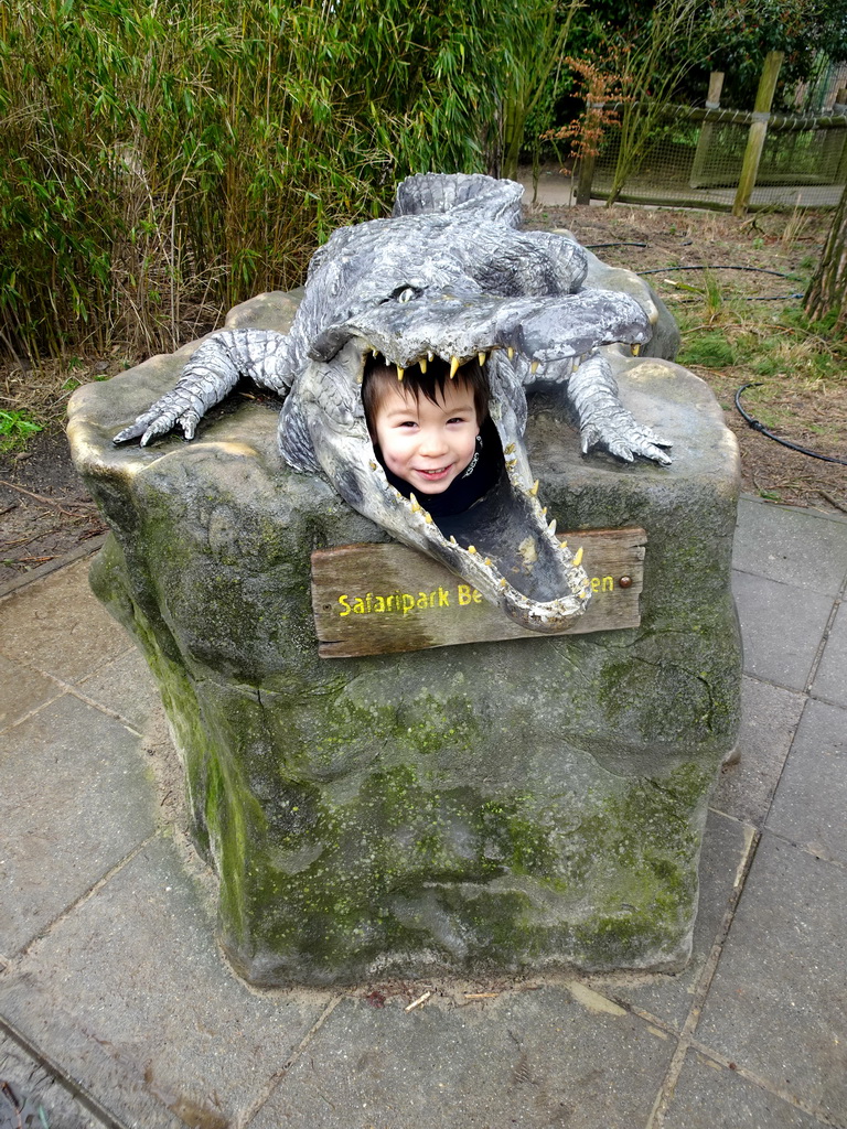 Max in a crocodile statue in front of the Hippopotamus and Crocodile enclosure at the Safaripark Beekse Bergen
