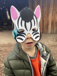 Max with a Zebra mask at the terrace of the restaurant at the Safariplein square at the Safaripark Beekse Bergen