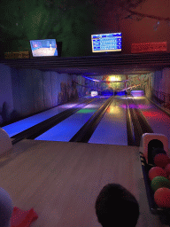 Max and a TV screen with the scores of the first round at the bowling alley at the Landal Miggelenberg holiday park