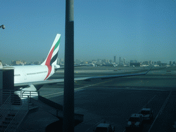 Skyscrapers in the city center of Dubai and an airplane, viewed from the Departure Gate at Dubai International Airport