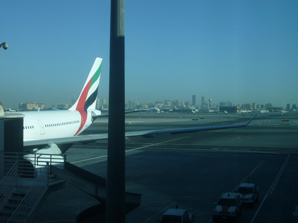Skyscrapers in the city center of Dubai and an airplane, viewed from the Departure Gate at Dubai International Airport