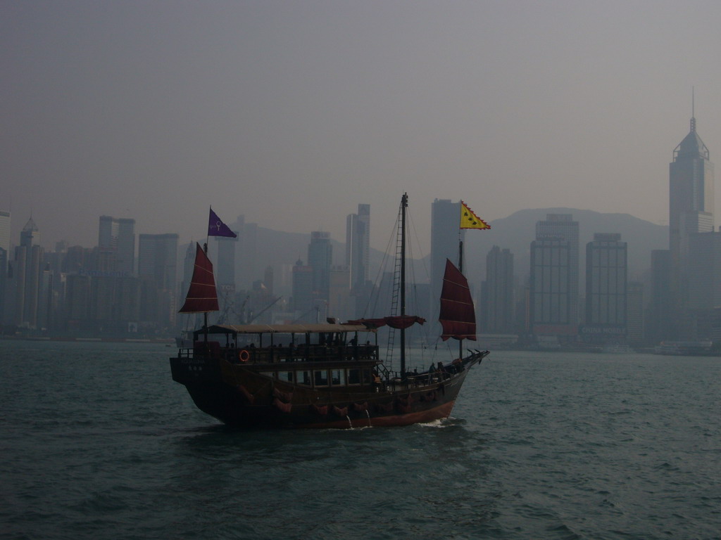 Boat in Victoria Harbour and the skyline of Hong Kong with the Central Plaza building, viewed from the Avenue of Stars