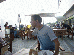 Tim with a beer on the terrace of a restaurant at the Avenue of Stars with the Central Plaza building