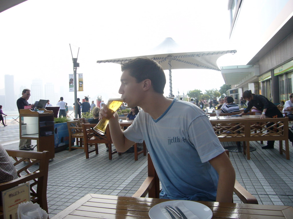 Tim with a beer on the terrace of a restaurant at the Avenue of Stars with the Central Plaza building