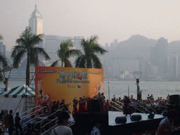 Dancers on a stage in front of the Hong Kong Museum of Art, with a view on Victoria Harbour and the skyline of Hong Kong with the Central Plaza building and the Hong Kong Convention and Exhibition Centre