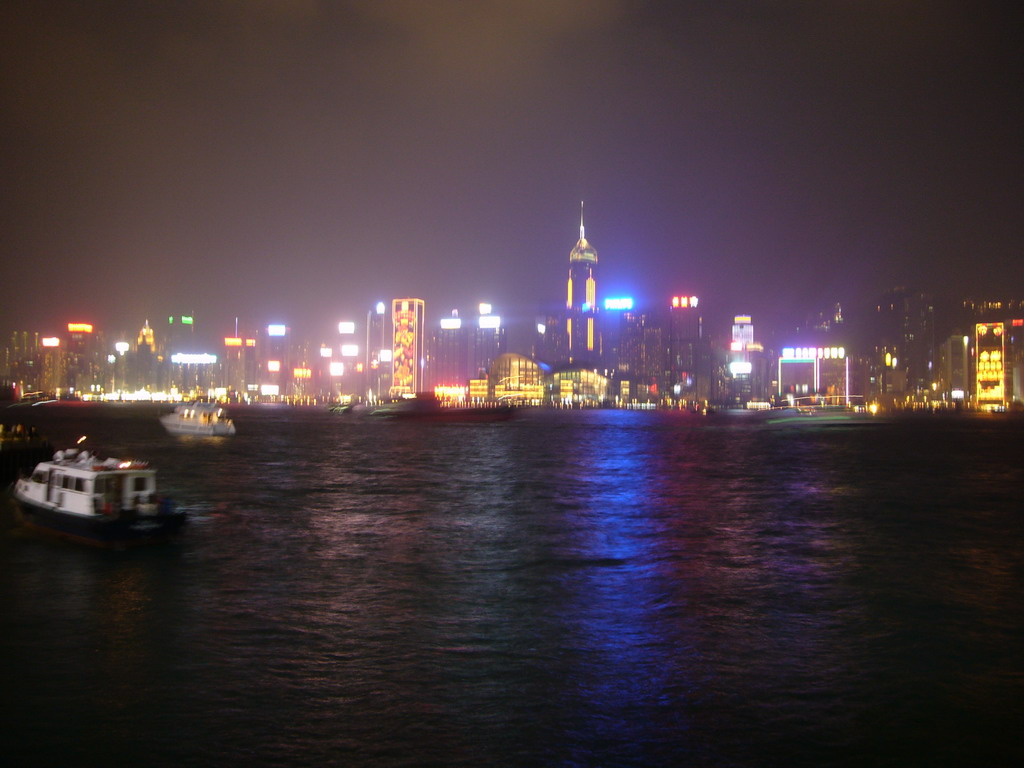 Boats in Victoria Harbour and the skyline of Hong Kong with the Hong Kong Convention and Exhibition Centre and the Central Plaza building, viewed from the Avenue of Stars, during the `A Symphony of Lights` light and sound show, by night