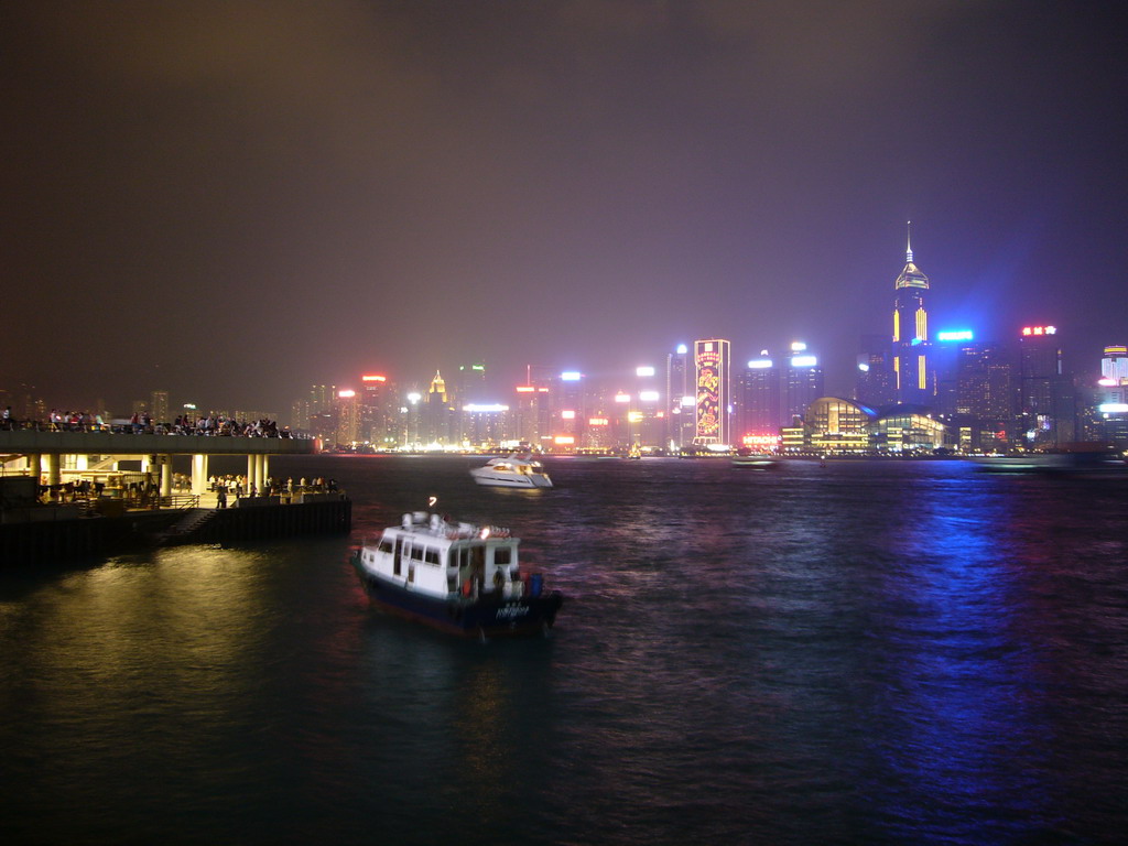 Boats in Victoria Harbour and the skyline of Hong Kong with the Hong Kong Convention and Exhibition Centre and the Central Plaza building, viewed from the Avenue of Stars, during the `A Symphony of Lights` light and sound show, by night