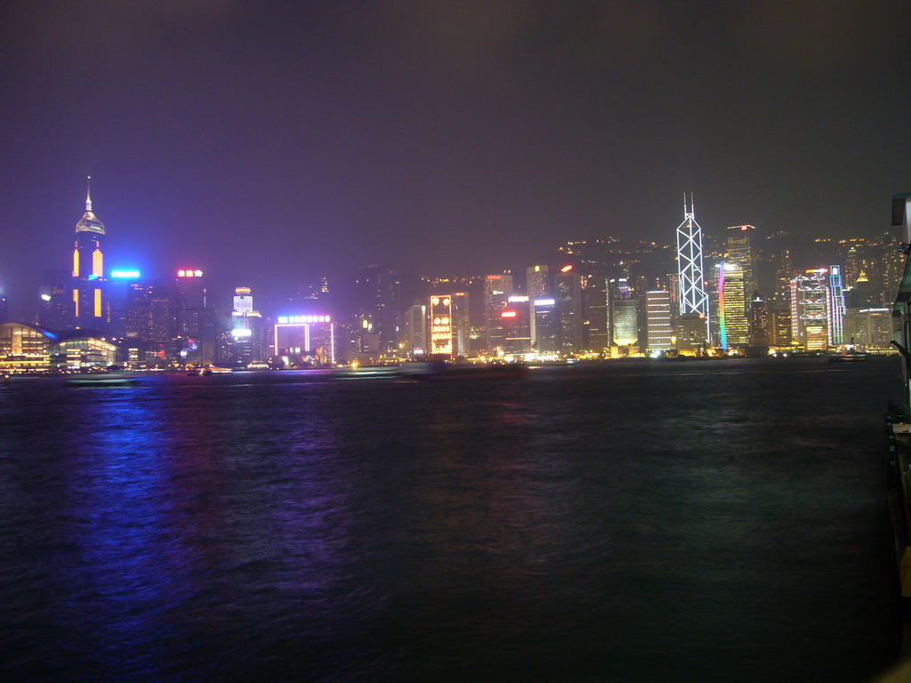 Boats in Victoria Harbour and the skyline of Hong Kong with the Hong Kong Convention and Exhibition Centre, the Central Plaza building and the Bank of China Tower, viewed from the Avenue of Stars, during the `A Symphony of Lights` light and sound show, by night