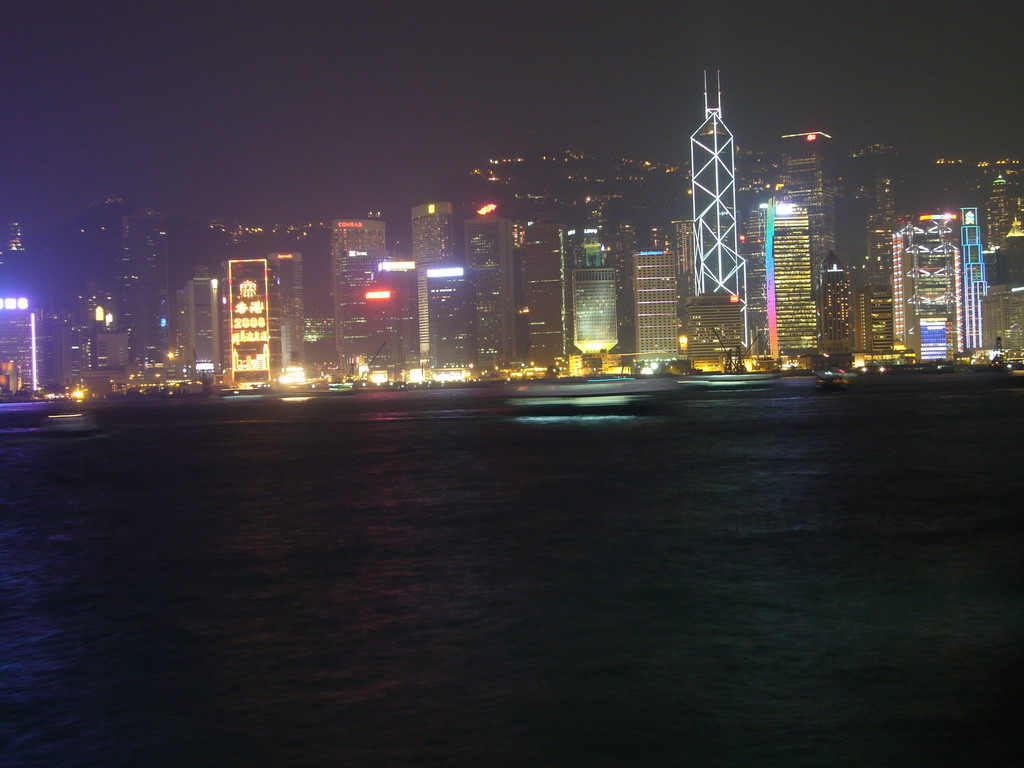 Boats in Victoria Harbour and the skyline of Hong Kong with the Bank of China Tower, viewed from the Avenue of Stars, during the `A Symphony of Lights` light and sound show, by night