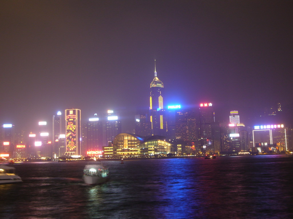 Boats in Victoria Harbour and the skyline of Hong Kong with the Hong Kong Convention and Exhibition Centre and the Central Plaza building, viewed from the Avenue of Stars, during the `A Symphony of Lights` light and sound show, by night