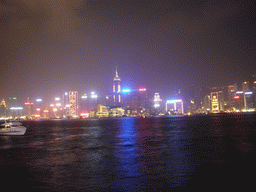 Boat in Victoria Harbour and the skyline of Hong Kong with the Hong Kong Convention and Exhibition Centre and the Central Plaza building, viewed from the Avenue of Stars, during the `A Symphony of Lights` light and sound show, by night