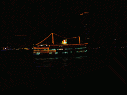Boat in Victoria Harbour and the skyline of Hong Kong, viewed from the Star Ferry from Kowloon to Hong Kong Island, by night