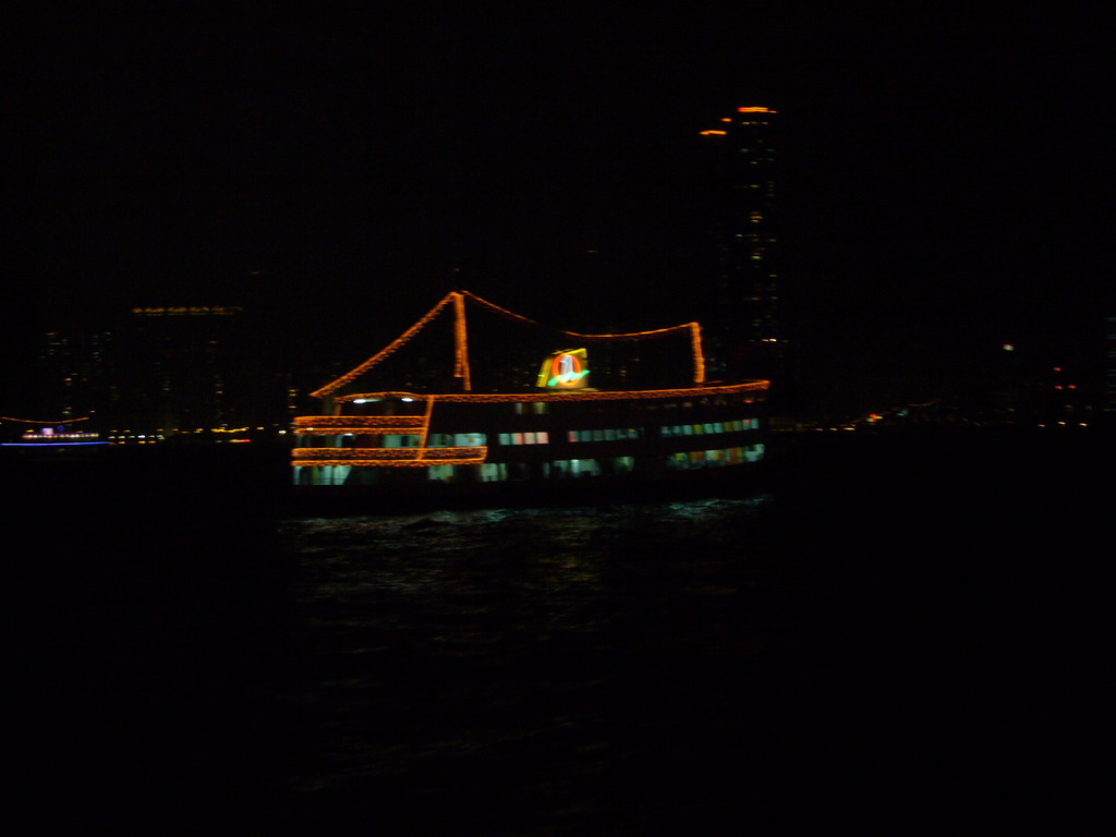 Boat in Victoria Harbour and the skyline of Hong Kong, viewed from the Star Ferry from Kowloon to Hong Kong Island, by night