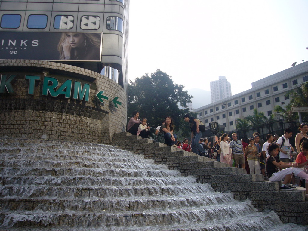 Miaomiao with a waterfall and the staircase to the Peak Tram at Peak Tower