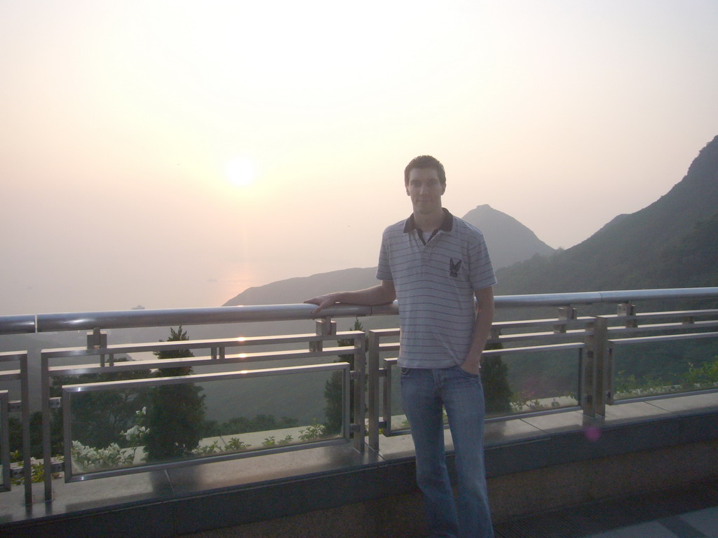Tim at Victoria Peak, with a view on the west side of Hong Kong Island with Mount Davis, at sunset