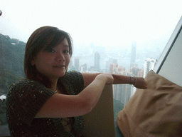 Miaomiao at the restaurant at Victoria Peak, with a view on the skyline of Hong Kong and Kowloon with the Two International Finance Centre, and Victoria Harbour, at sunset