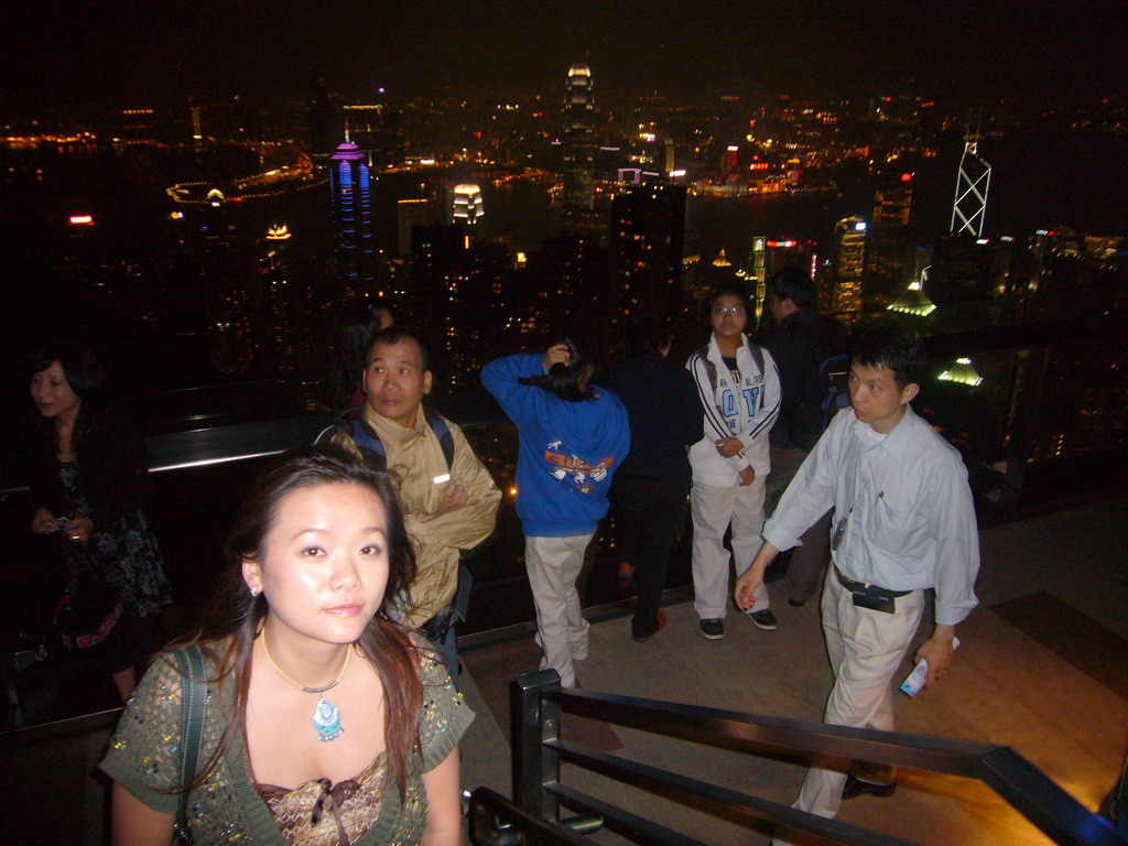 Miaomiao at Victoria Peak, with a view on the skyline of Hong Kong and Kowloon with the Two International Finance Centre and the Bank of China Tower, and Victoria Harbour, by night