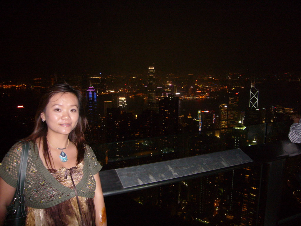 Miaomiao at Victoria Peak, with a view on the skyline of Hong Kong and Kowloon with the Two International Finance Centre and the Bank of China Tower, and Victoria Harbour, by night