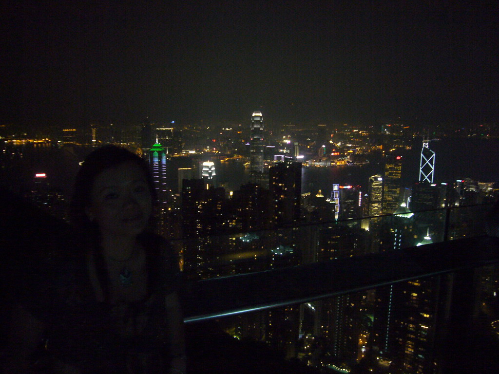 Miaomiao at Victoria Peak, with a view on the skyline of Hong Kong and Kowloon with the Two International Finance Centre and the Bank of China Tower, and Victoria Harbour, by night