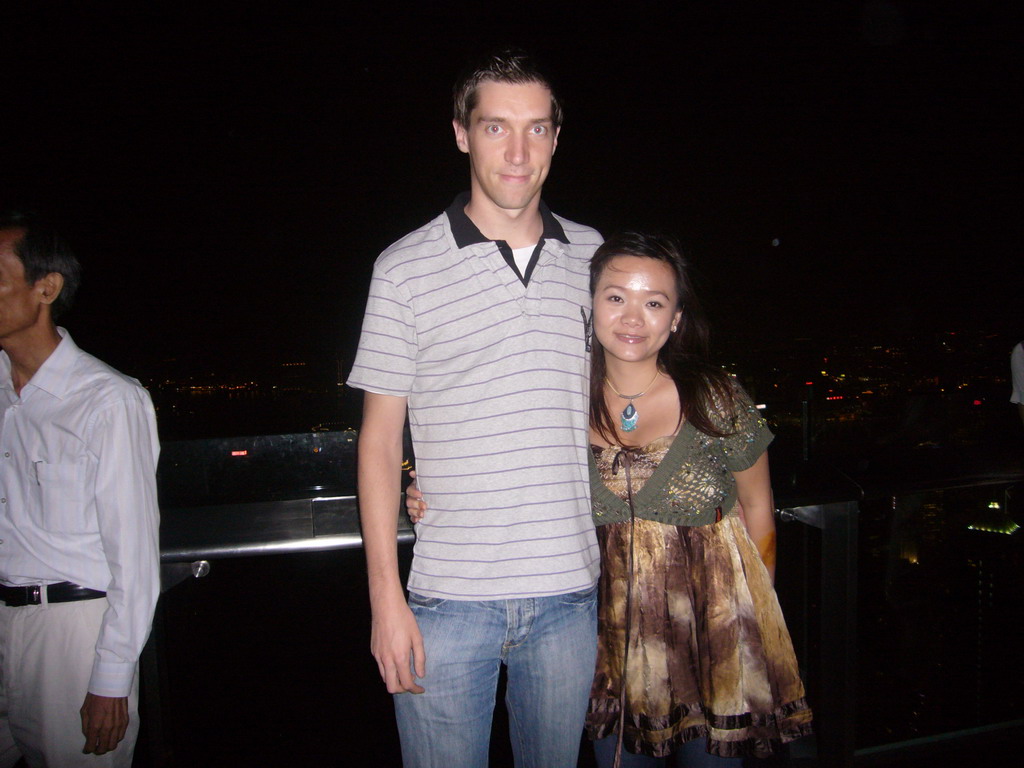 Tim and Miaomiao at Victoria Peak, with a view on the skyline of Hong Kong and Kowloon, and Victoria Harbour, by night