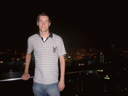 Tim at Victoria Peak, with a view on the skyline of Hong Kong and Kowloon with the Bank of China Tower, and Victoria Harbour, by night