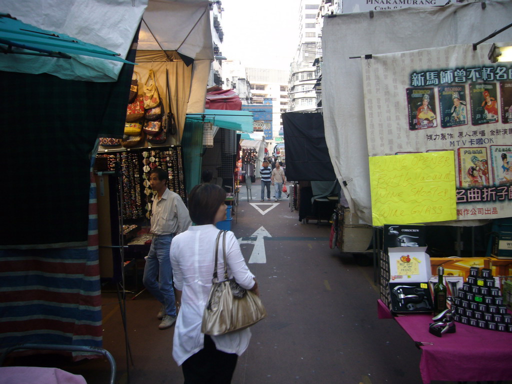 Miaomiao in a street with market stalls at Kowloon