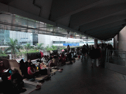 People sitting in a pedestrian passage over Connaught Road