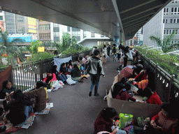 People sitting in a pedestrian passage over Connaught Road