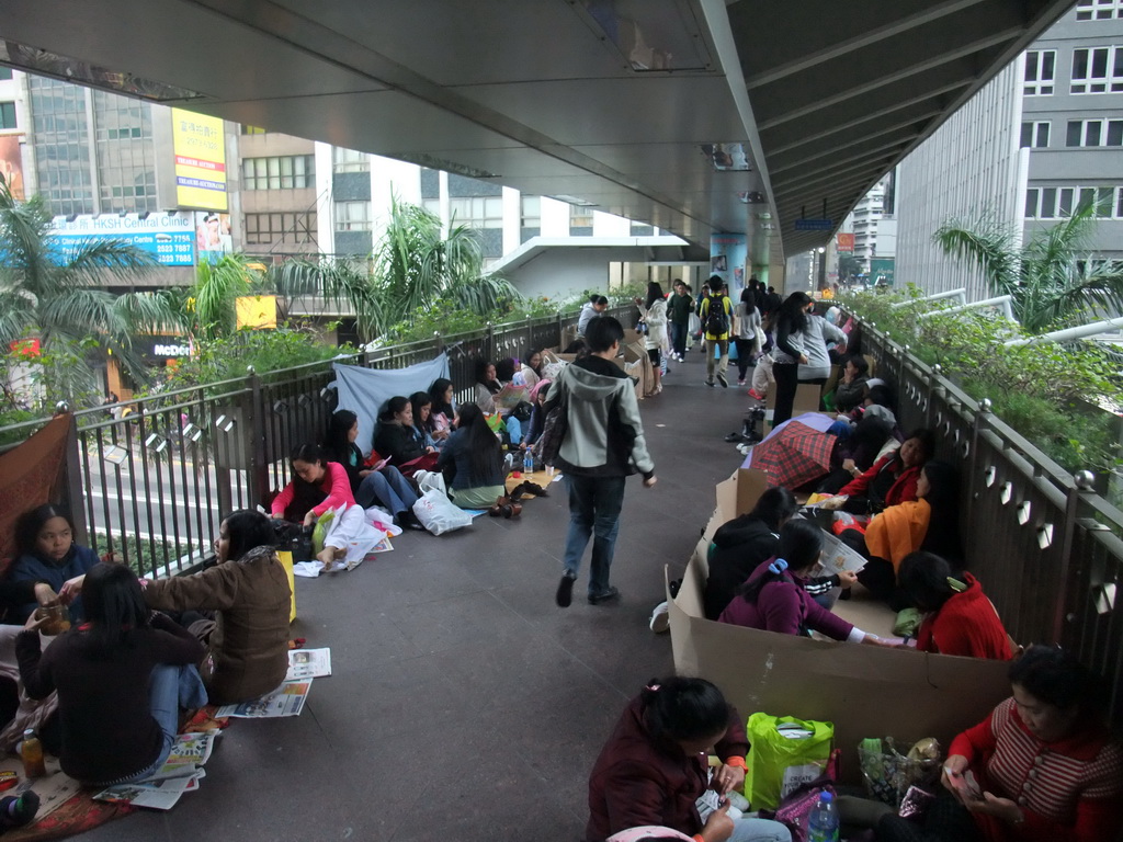 People sitting in a pedestrian passage over Connaught Road