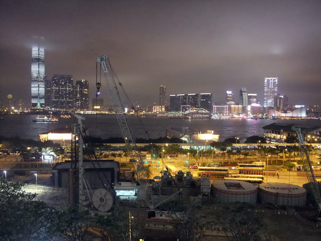 Victoria Harbour with Central Ferry Pier 5, 6 and 7, and the skyline of Kowloon with the International Commerce Centre, viewed from the roof terrace of the IFC Mall, by night