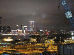 Victoria Harbour with the Star Ferry Pier and the skyline of Kowloon during the `A Symphony of Lights` multimedia show, viewed from the roof terrace of the IFC Mall, by night